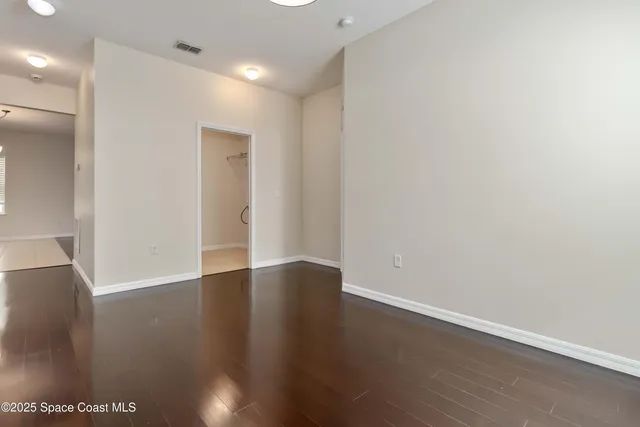 a view of an empty room with wooden floor