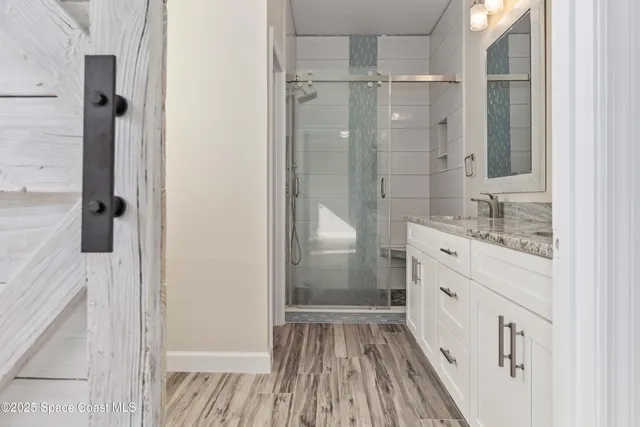a bathroom with a sink a mirror a vanity and shower