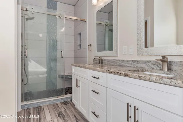 a bathroom with a granite countertop shower sink and mirror