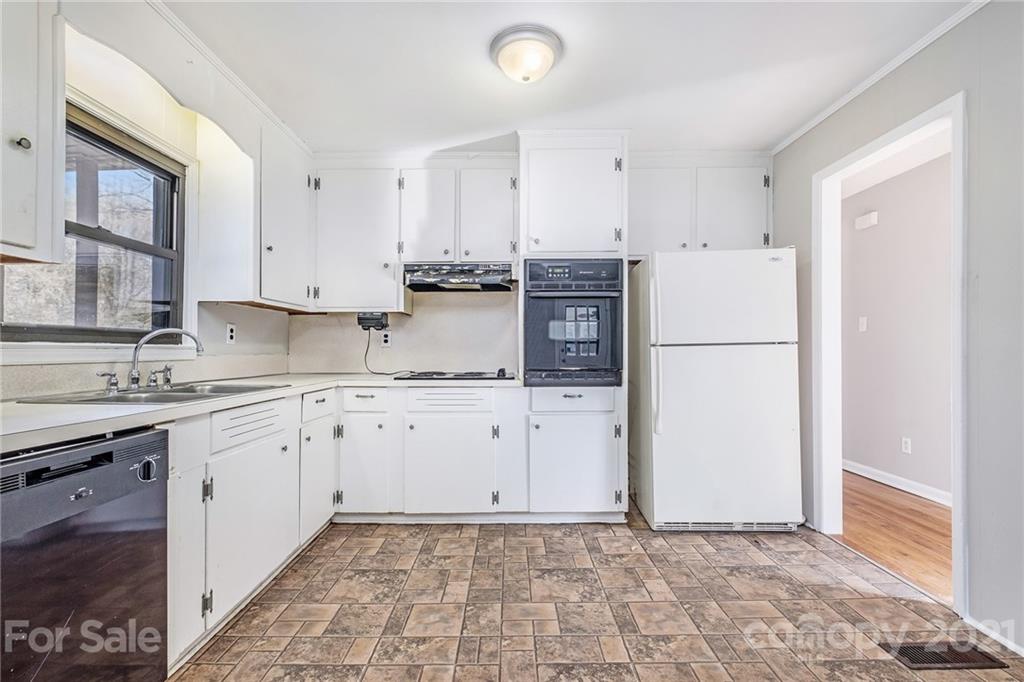 135 Eller Road Gastonia, NC 28056 - Photo 6 of 17 a kitchen with granite countertop a refrigerator sink stove and white cabinets
