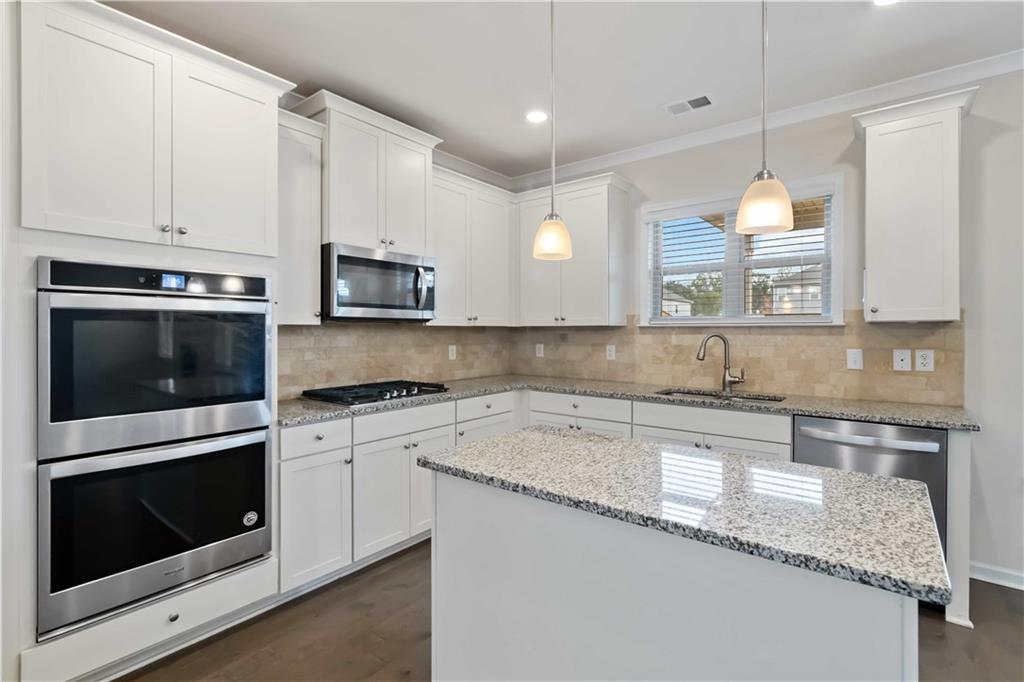 156 Beaumont Way Hampton, GA 30228 - Photo 11 of 21 a kitchen with granite countertop white cabinets and a stove