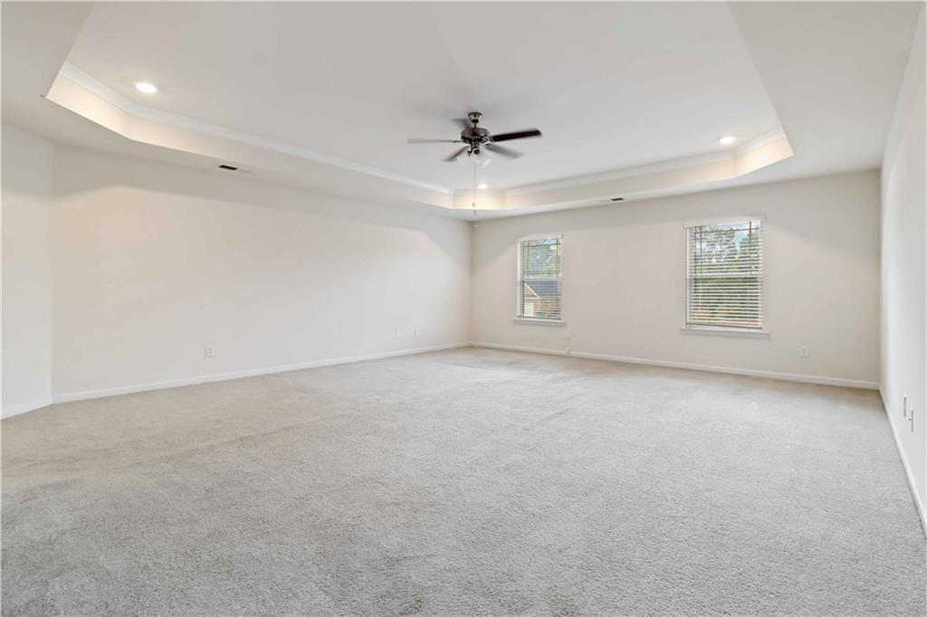 156 Beaumont Way Hampton, GA 30228 - Photo 12 of 21 an empty room with a ceiling fan and windows