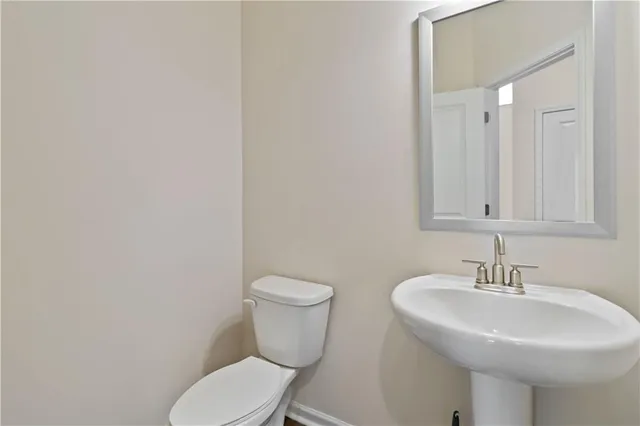 a bathroom with a sink a toilet and mirror