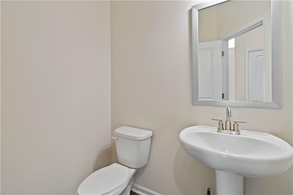 156 Beaumont Way Hampton, GA 30228 - Photo 6 of 21 a bathroom with a sink a toilet and mirror