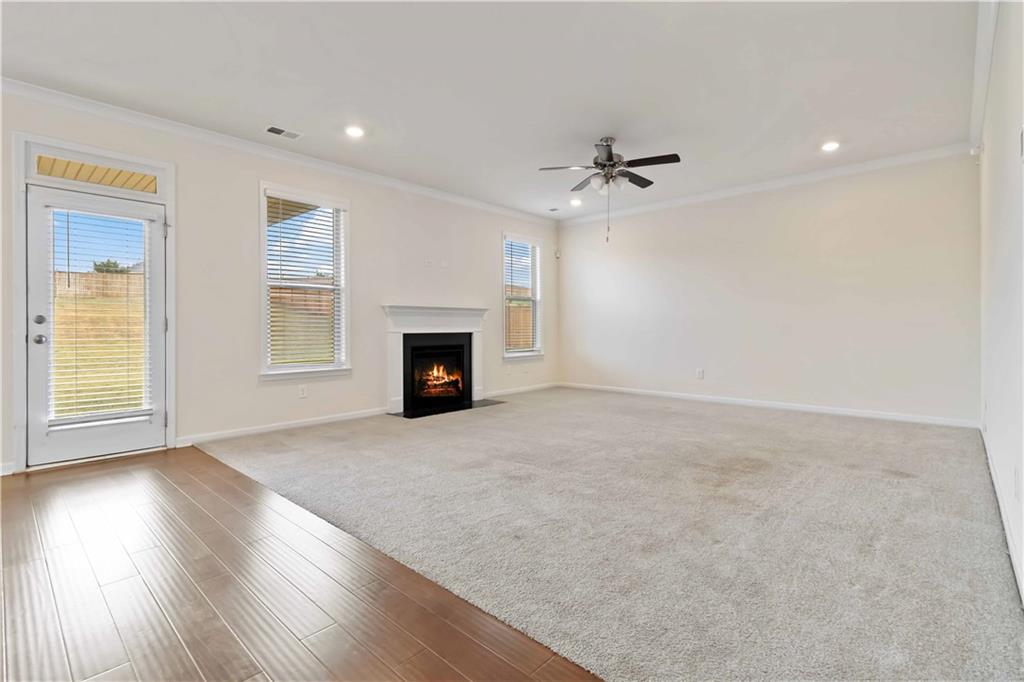 156 Beaumont Way Hampton, GA 30228 - Photo 7 of 21 an empty room with windows fireplace and a wooden floor