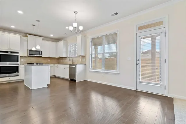 a view of kitchen with granite countertop stove top oven and cabinets