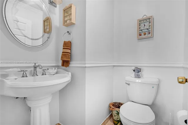 a bathroom with a sink mirror and toilet