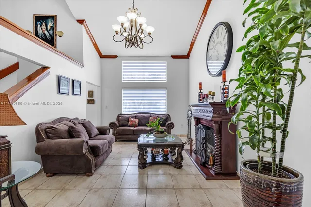 a living room with furniture a fireplace and a chandelier