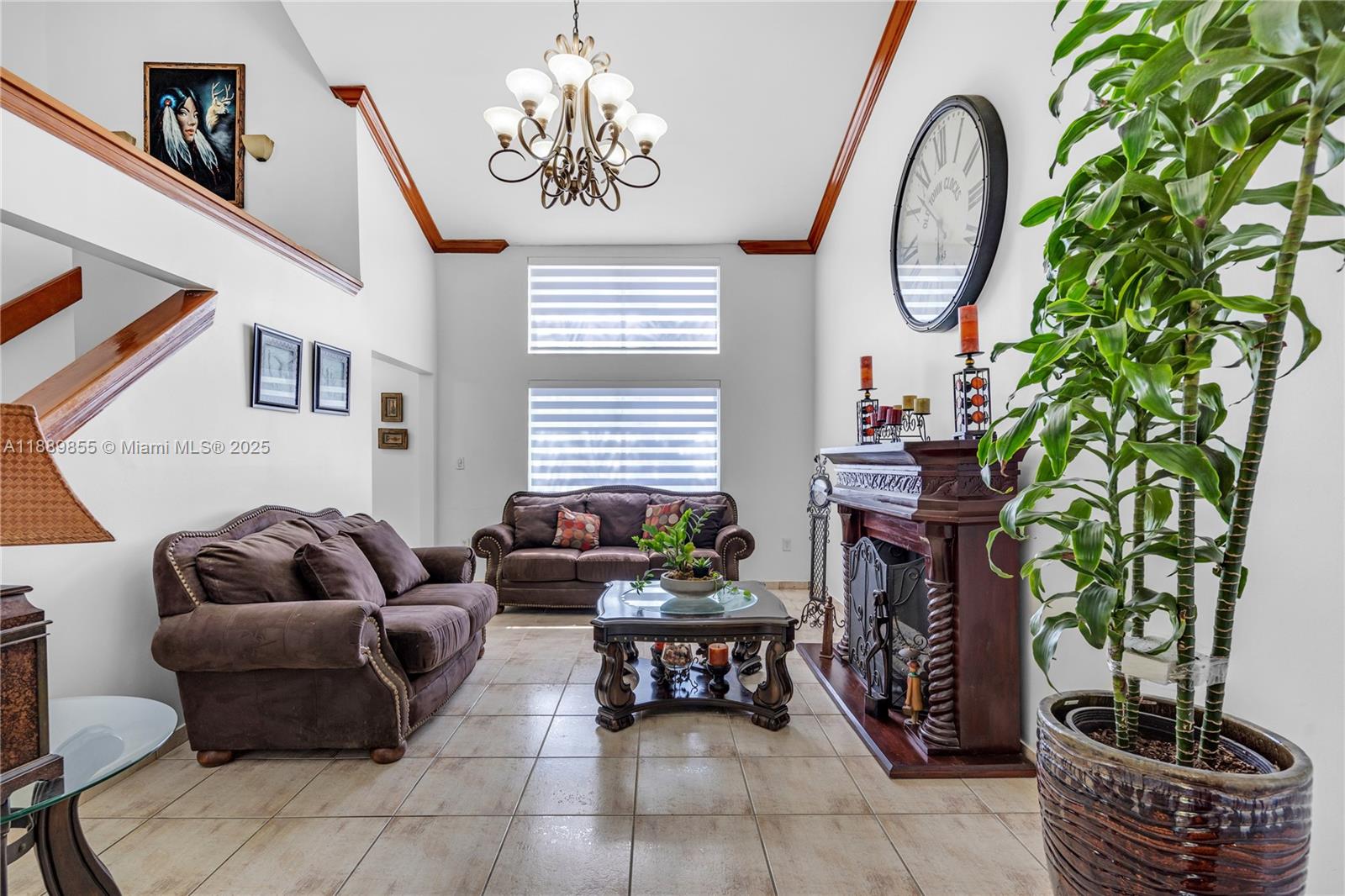 10213 Southwest 156th Avenue Miami, FL 33196 - Photo 8 of 29 a living room with furniture a fireplace and a chandelier