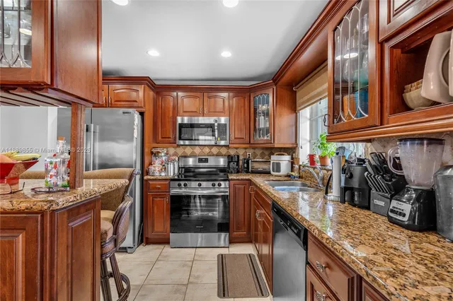 a kitchen with stainless steel appliances granite countertop a sink stove and refrigerator