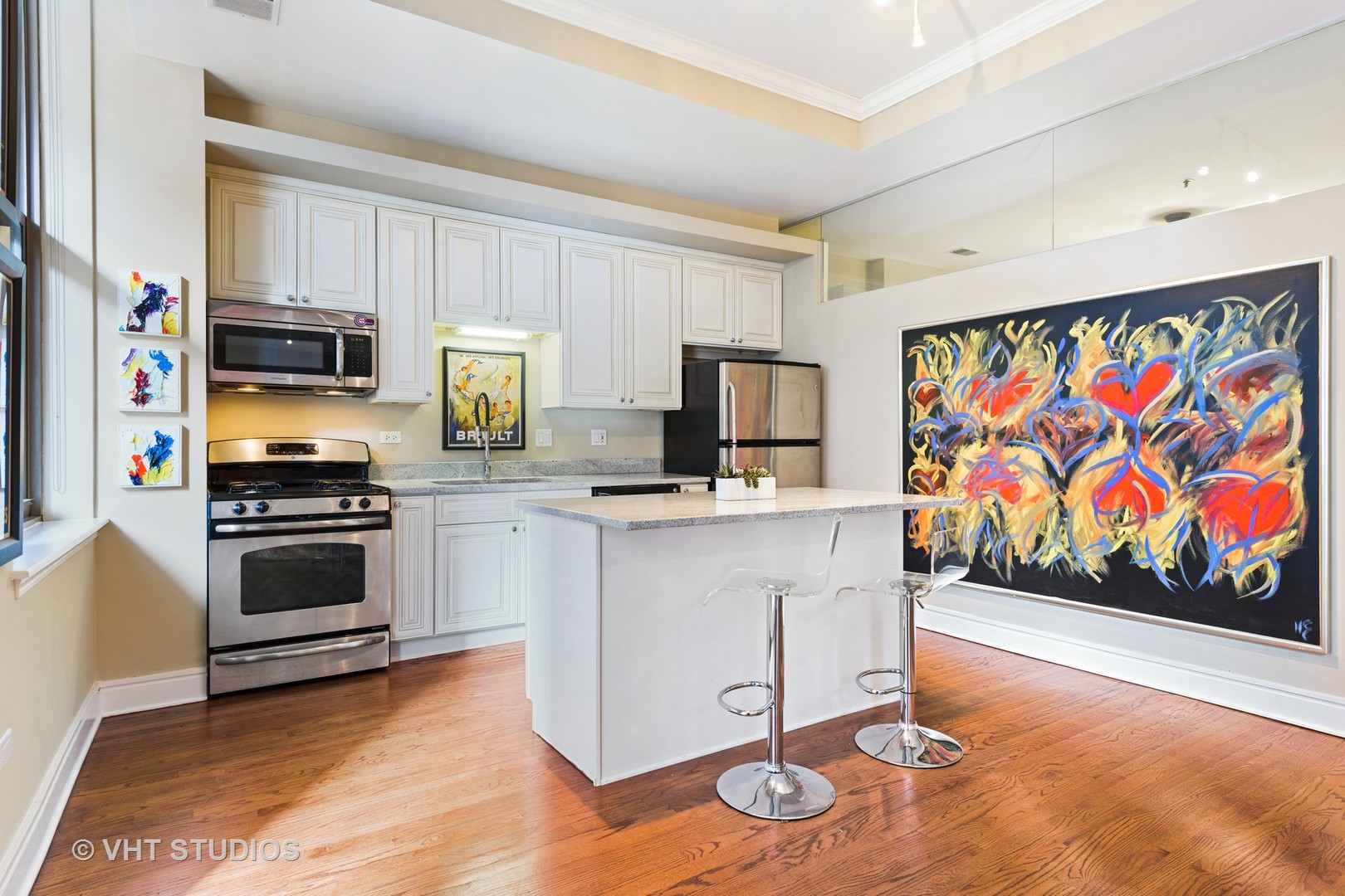 212 West Washington Street, Unit 1002 Chicago, IL 60606 - Photo 6 of 12 a kitchen with stainless steel appliances kitchen island granite countertop a stove and cabinets
