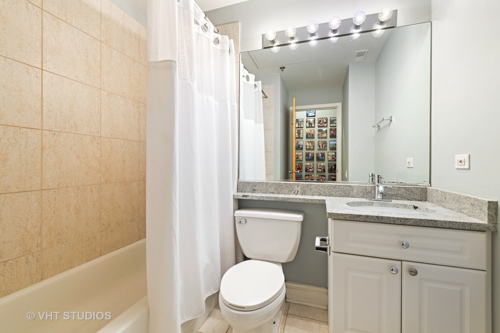 212 West Washington Street, Unit 1002 Chicago, IL 60606 - Photo 10 of 12 a bathroom with a granite countertop sink toilet and shower