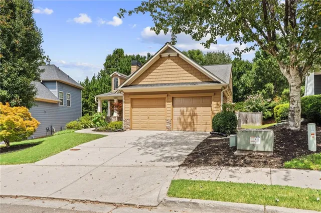 a front view of a house with a yard and potted plants