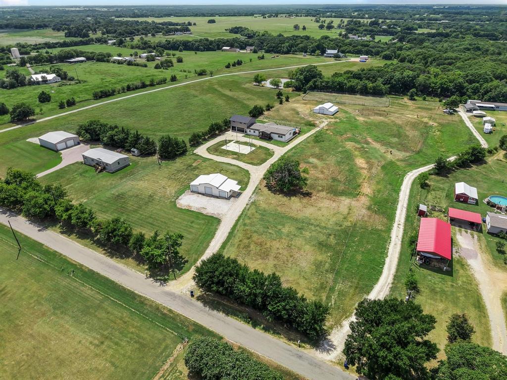 an aerial view of residential houses with outdoor space and trees