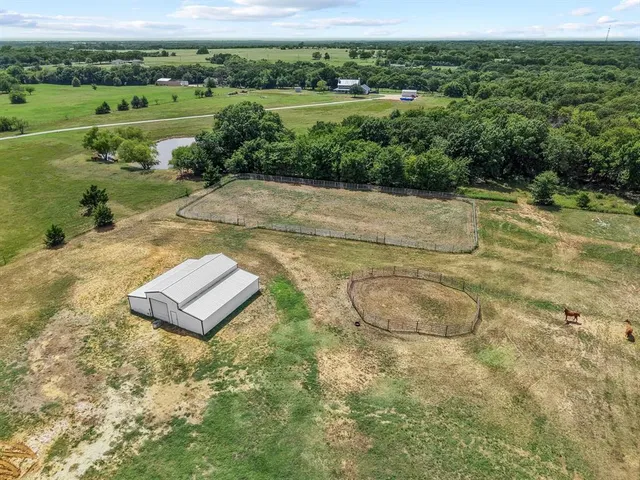a view of a lake with a yard and large trees