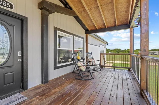 a view of a balcony with chairs and wooden floor