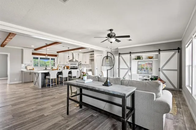 a living room with furniture and a wooden floor
