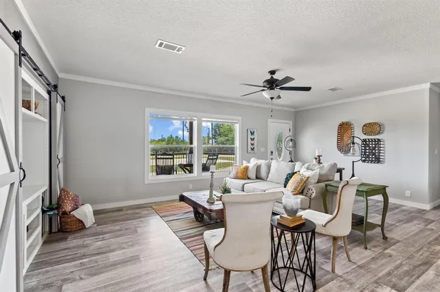 a living room with furniture a window and a flat screen tv