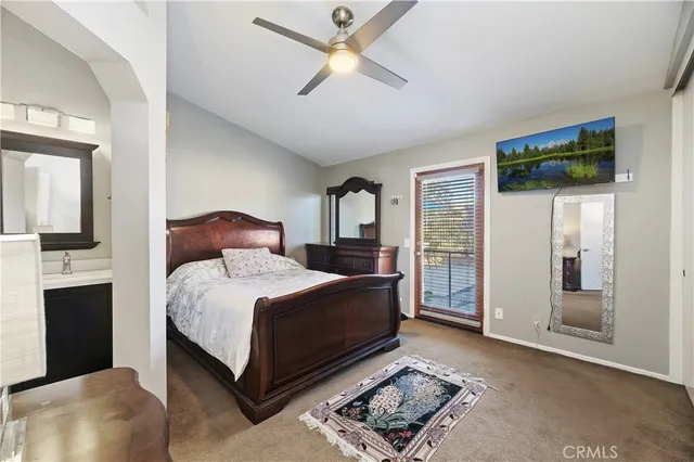 a bedroom with a bed lamp and a large window