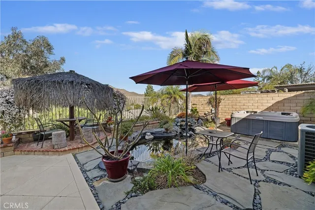 a view of a patio with chairs and table under an umbrella with the patio
