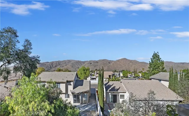 an aerial view of residential houses with outdoor space and trees