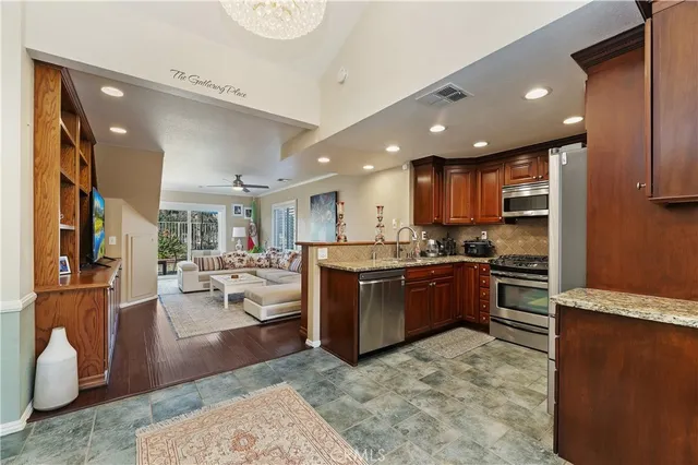 a kitchen with stainless steel appliances kitchen island granite countertop a refrigerator and a stove