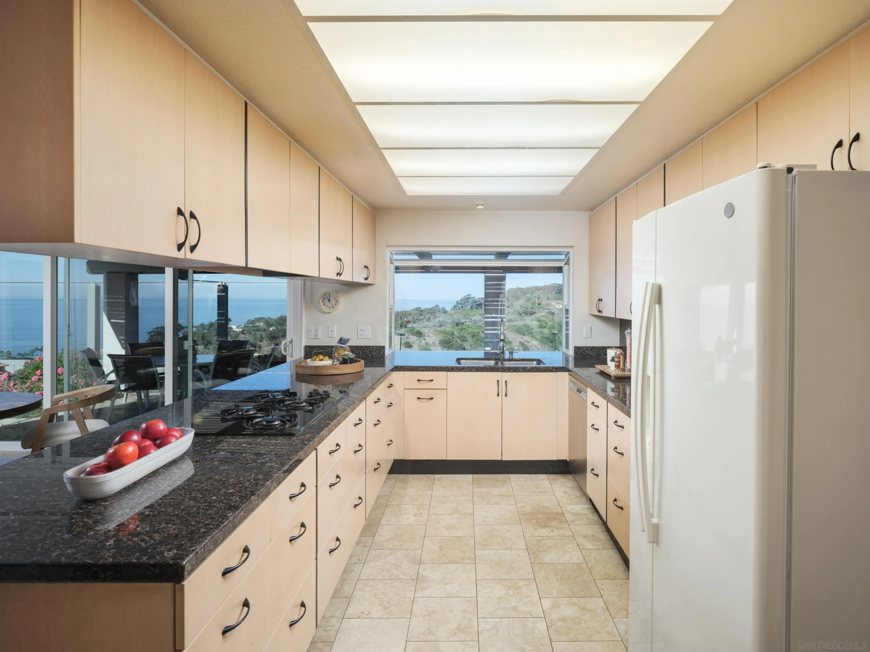 8568 Prestwick Drive La Jolla, CA 92037 - Photo 18 of 39 a kitchen with stainless steel appliances granite countertop a refrigerator a sink dishwasher a stove and white countertops with wooden floor
