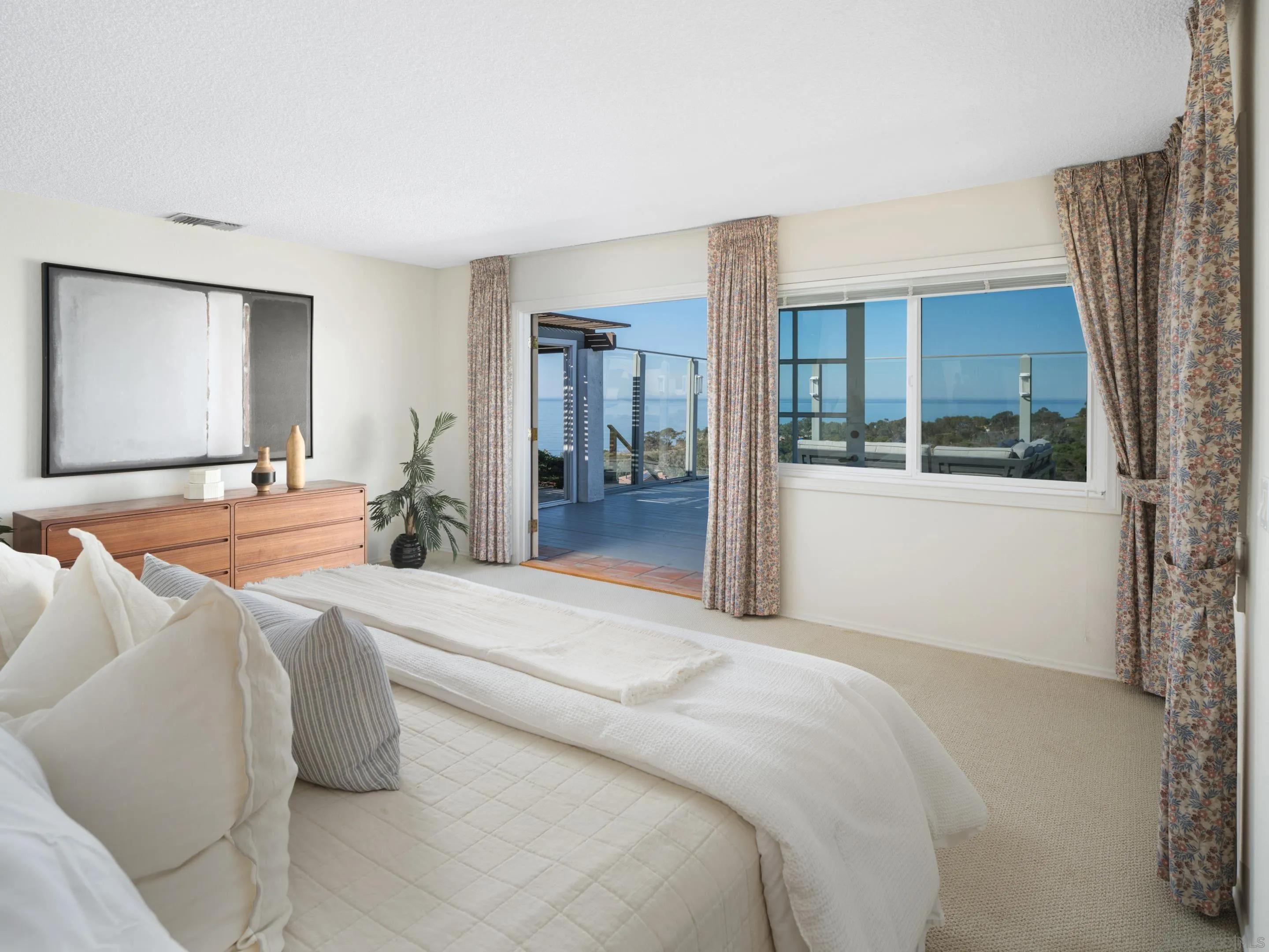 8568 Prestwick Drive La Jolla, CA 92037 - Photo 19 of 39 a spacious bedroom with a bed and glass door