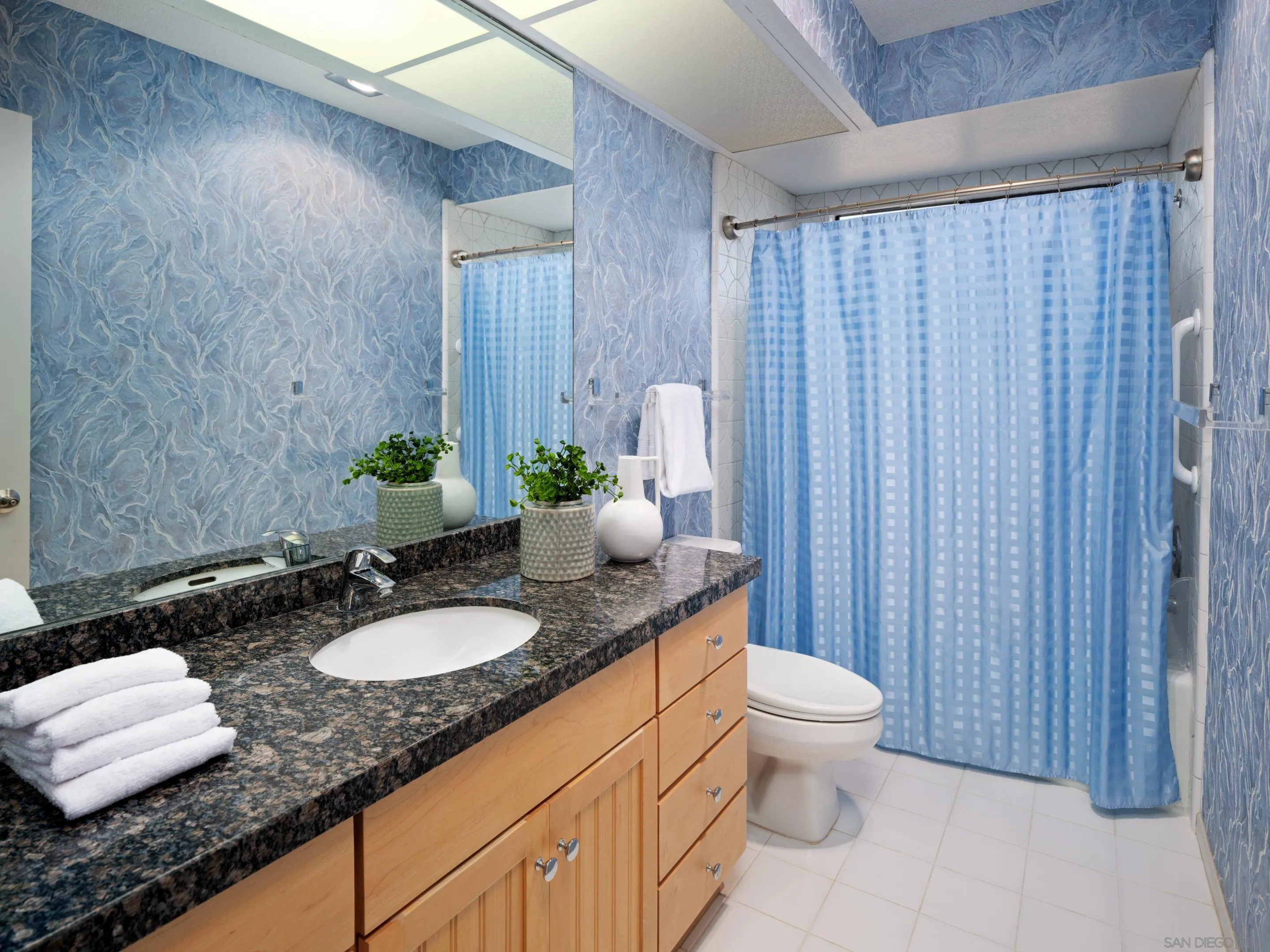 8568 Prestwick Drive La Jolla, CA 92037 - Photo 33 of 39 a bathroom with a granite countertop sink and a mirror