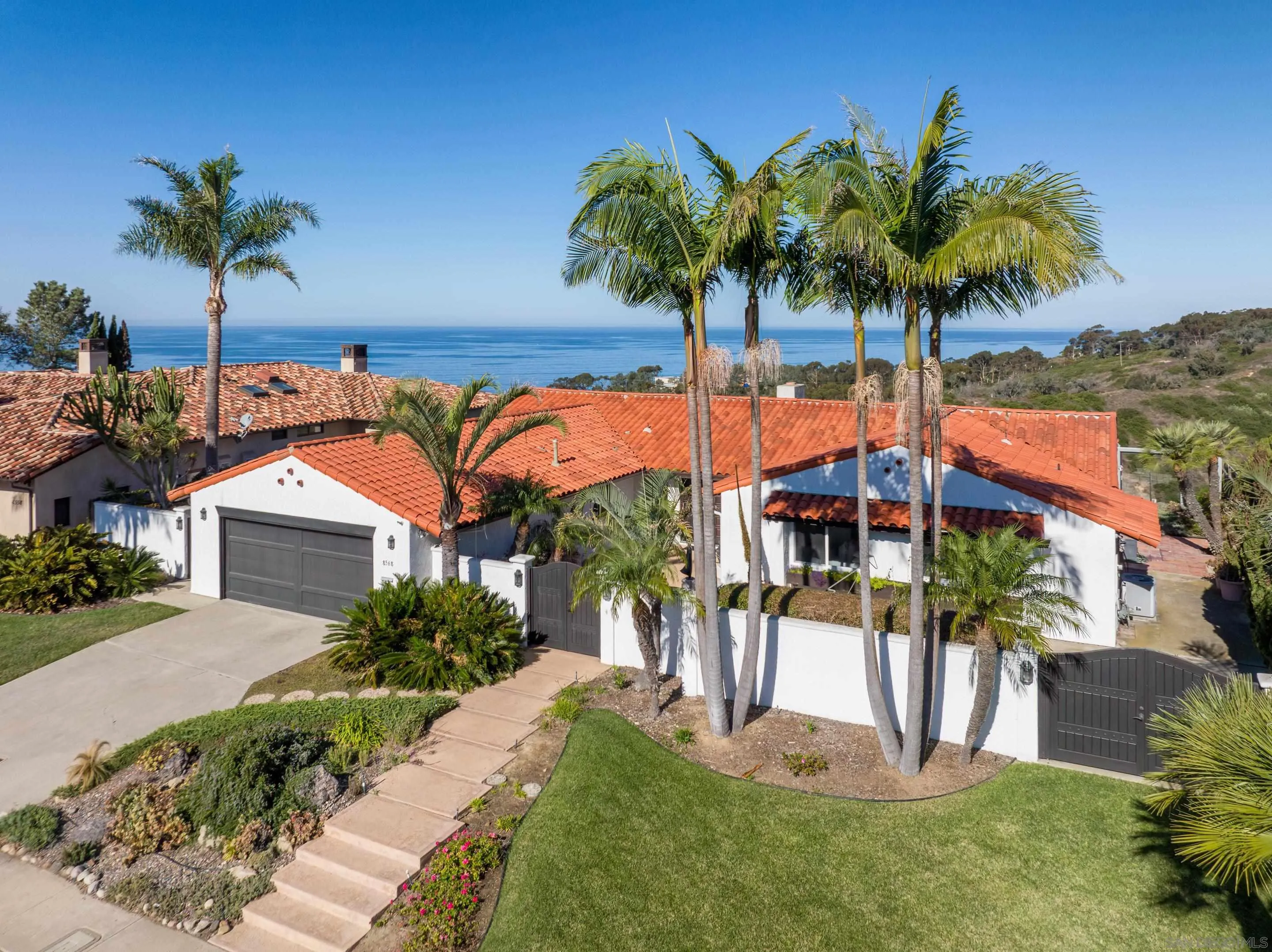 8568 Prestwick Drive La Jolla, CA 92037 - Photo 7 of 39 a front view of a house with a garden and swimming pool