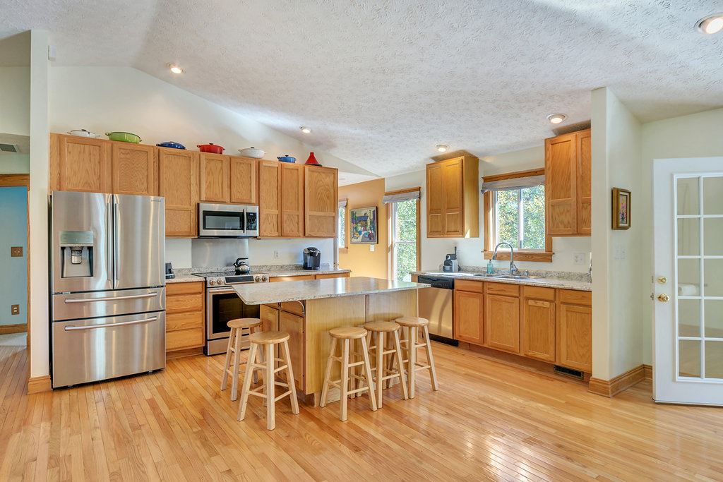 1452 Courthouse Road Palmyra, VA 22963 - Photo 19 of 44 a kitchen with stainless steel appliances granite countertop a refrigerator a stove top oven a sink dishwasher and white cabinets with wooden floor
