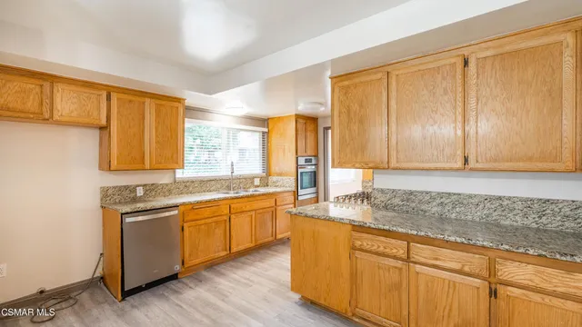 a kitchen with stainless steel appliances granite countertop cabinets and wooden floor
