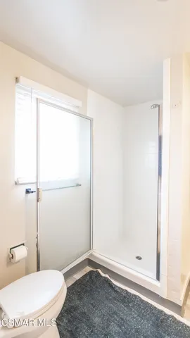 a bathroom with a toilet and a shower