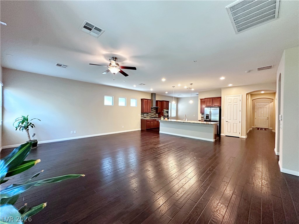 71 Newton Ridge Way Las Vegas, NV 89183 - Photo 10 of 40 Rich hardwood floors flow through this luminous open-concept living space and kitchen.