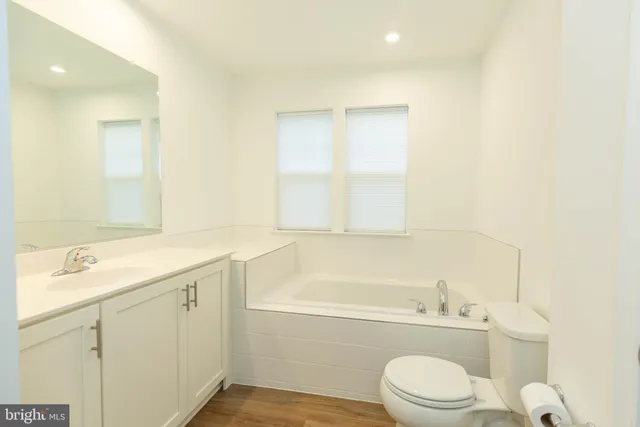 a bathroom with a granite countertop toilet a sink and a bathtub