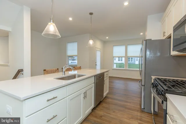 a kitchen with a sink chandelier and wooden floor