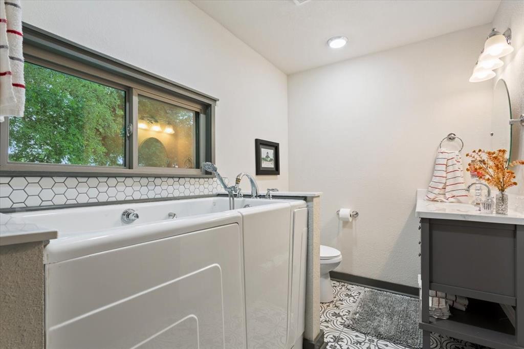 649 Wedgewood Drive China Spring, TX 76633 - Photo 23 of 39 Full bathroom with vanity, a bath, and dark tile patterned flooring