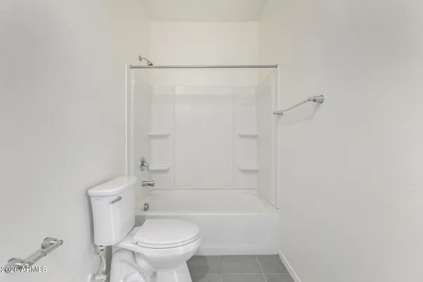 a white toilet sitting next to a bath tub