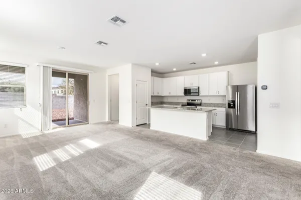 a view of a kitchen with refrigerator and white cabinets