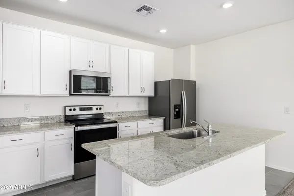 a kitchen with stainless steel appliances granite countertop a sink a stove and refrigerator