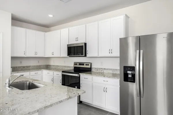 a kitchen with white cabinets and stainless steel appliances