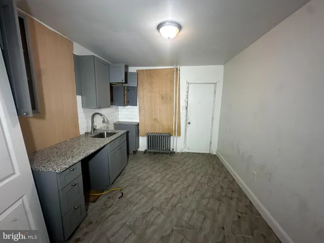 a kitchen with granite countertop a sink and refrigerator