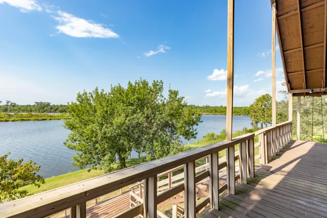 a view of balcony with wooden floor & fence