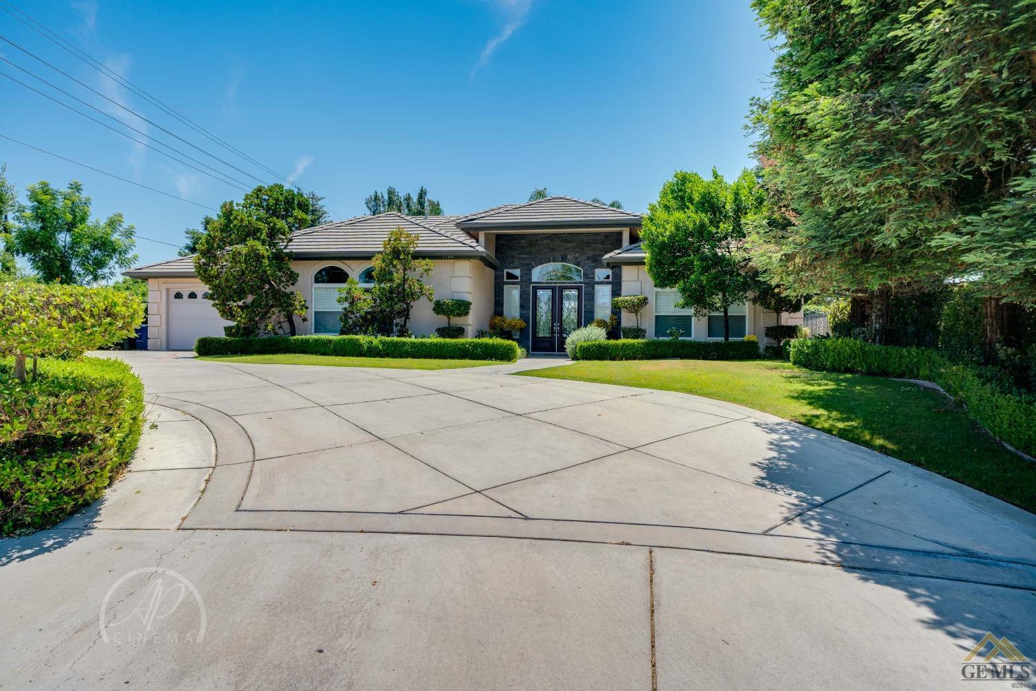 a front view of a house with a yard and potted plants