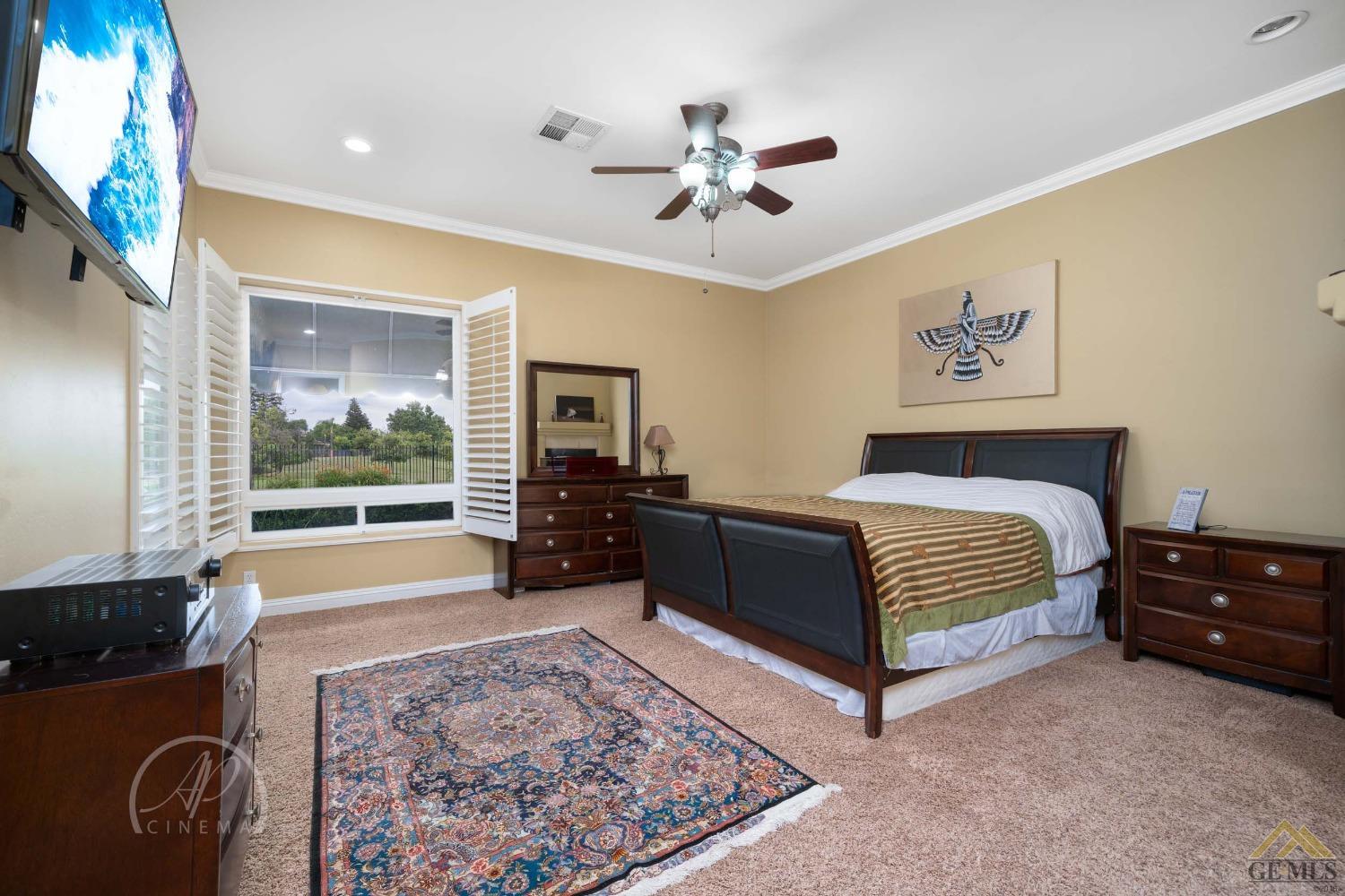 Undisclosed Address Bakersfield, CA 93311 - Photo 13 of 33 a spacious bedroom with a bed and dresser with mirror