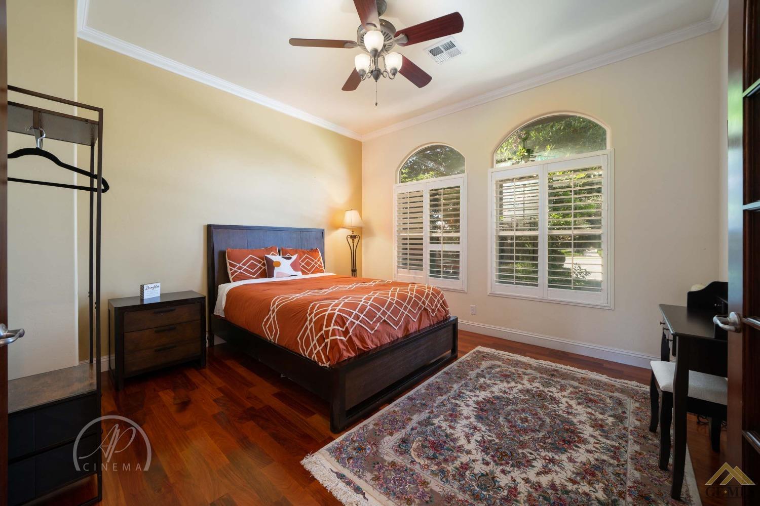 Undisclosed Address Bakersfield, CA 93311 - Photo 19 of 33 a spacious bedroom with a bed a dresser and wooden floor