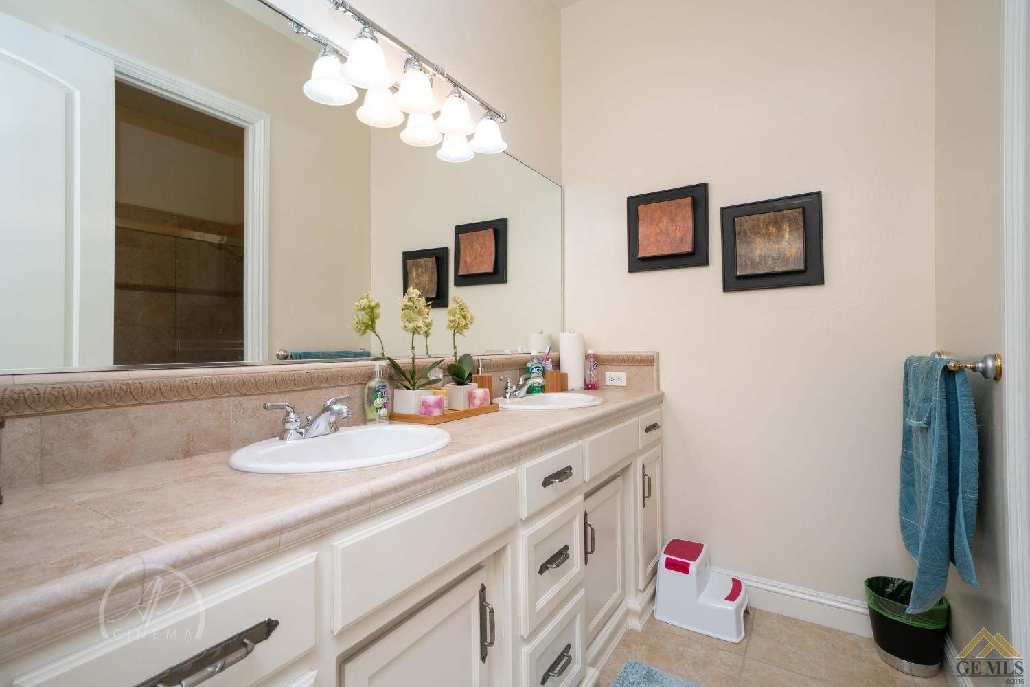 Undisclosed Address Bakersfield, CA 93311 - Photo 21 of 33 a bathroom with a double vanity sink and a mirror