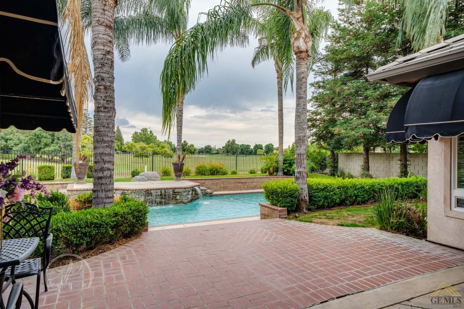 Undisclosed Address Bakersfield, CA 93311 - Photo 25 of 33 a view of a garden with a bench and trees around
