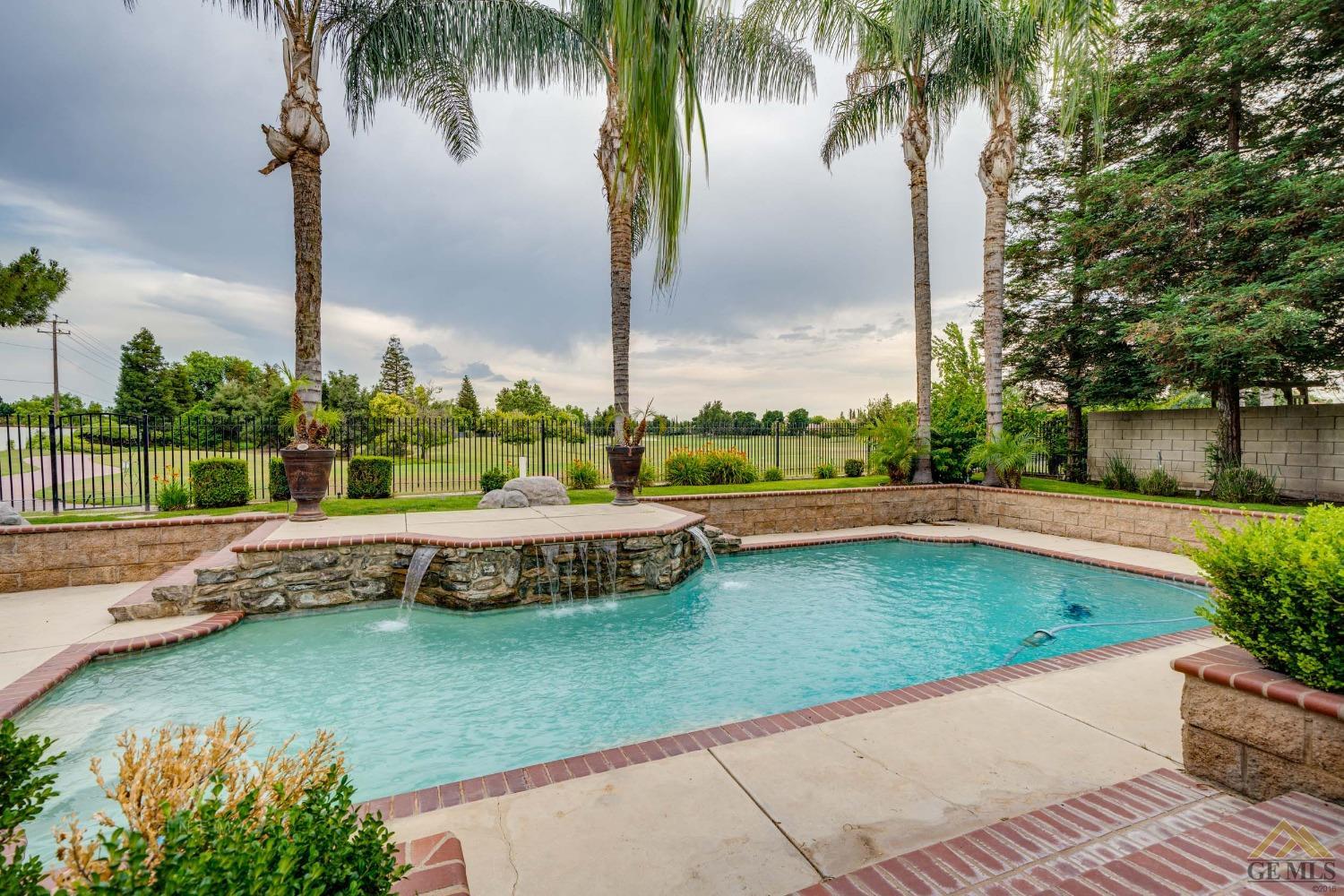 Undisclosed Address Bakersfield, CA 93311 - Photo 27 of 33 a view of a swimming pool with a garden and plants
