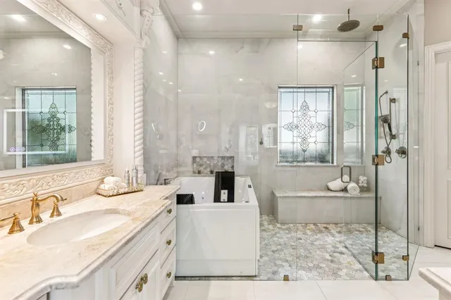 a bathroom with a granite countertop tub sink and mirror
